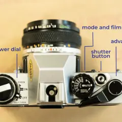Överdelen av en Olympus OM-10 med reglage för filmframmatning, slutare och filmhastighet.