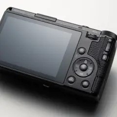 Svart Ricoh GR IV-kamera med stor skärm och knappar för inställningar.