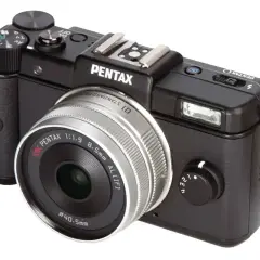 Svart kompaktkamera Pentax Q med silverfärgad lins. Perfekt för att fånga ögonblick.