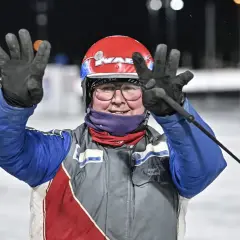 Jenny Rehnman vinkar glatt med båda händerna, klädd i tävlingskläder och hjälm.