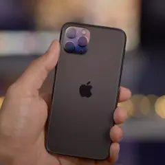 En hand håller en mörk iPhone 11 Pro med sin imponerande trippelkamera.