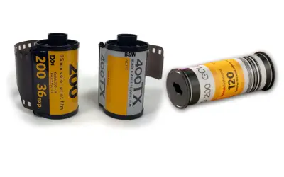 Tre filmrullar: en 35mm färgfilm, en 35mm svartvit film och en 120-film. Dessa visar hur framkallar man bilder från analog film.