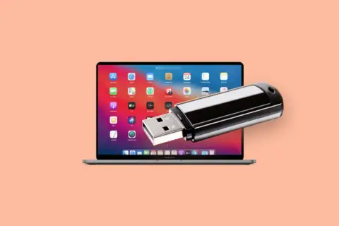 En MacBook Pro med en USB-sticka som sticker ut från skärmen, perfekt för att spara bilder på usb-minne.