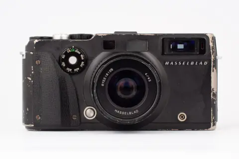 En sliten men ikonisk Hasselblad XPan-kamera med vidvinkelobjektiv. Den har sett bättre dagar men är redo för nya äventyr.