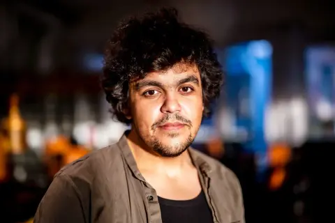Alexander Mahmoud, en ung man med lockigt mörkt hår och skäggstubb, blickar mot kameran.