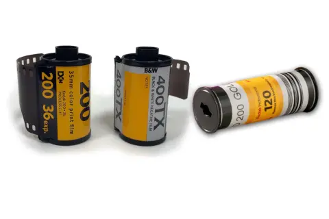 Tre filmrullar: en 35mm färgfilm, en 35mm svartvit film och en 120-film. Dessa visar hur framkallar man bilder från analog film.