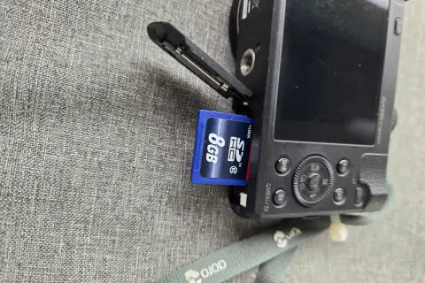 Ett SD-kort på 8GB sätts in i en Panasonic Lumix TZ60.
