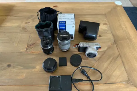 Här ligger en Panasonic GM1 med tillbehör: objektiv, laddare, batteri och fodral. Perfekt för den som vill fotografera.