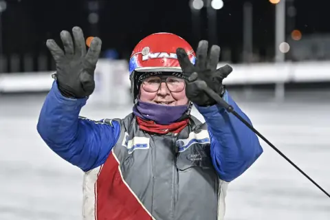 Jenny Rehnman vinkar glatt med båda händerna, klädd i tävlingskläder och hjälm.