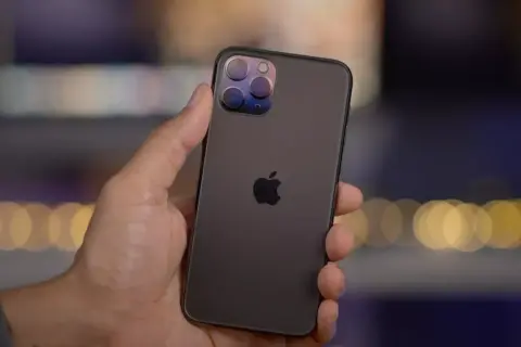 En hand håller en mörk iPhone 11 Pro med sin imponerande trippelkamera.