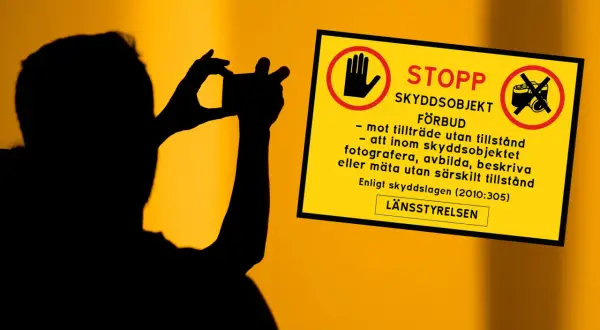 Silhuett av person som fotograferar. Gul skylt med texten "STOPP SKYDDSOBJEKT FÖRBUD" och symboler som varnar för att fotografera, avbilda eller mäta utan tillstånd.
