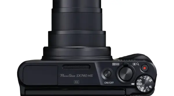 Svart Canon PowerShot SX740 HS kamera med zoomobjektiv och kontrollhjul. Perfekt för att fånga dina äventyr i 4K.