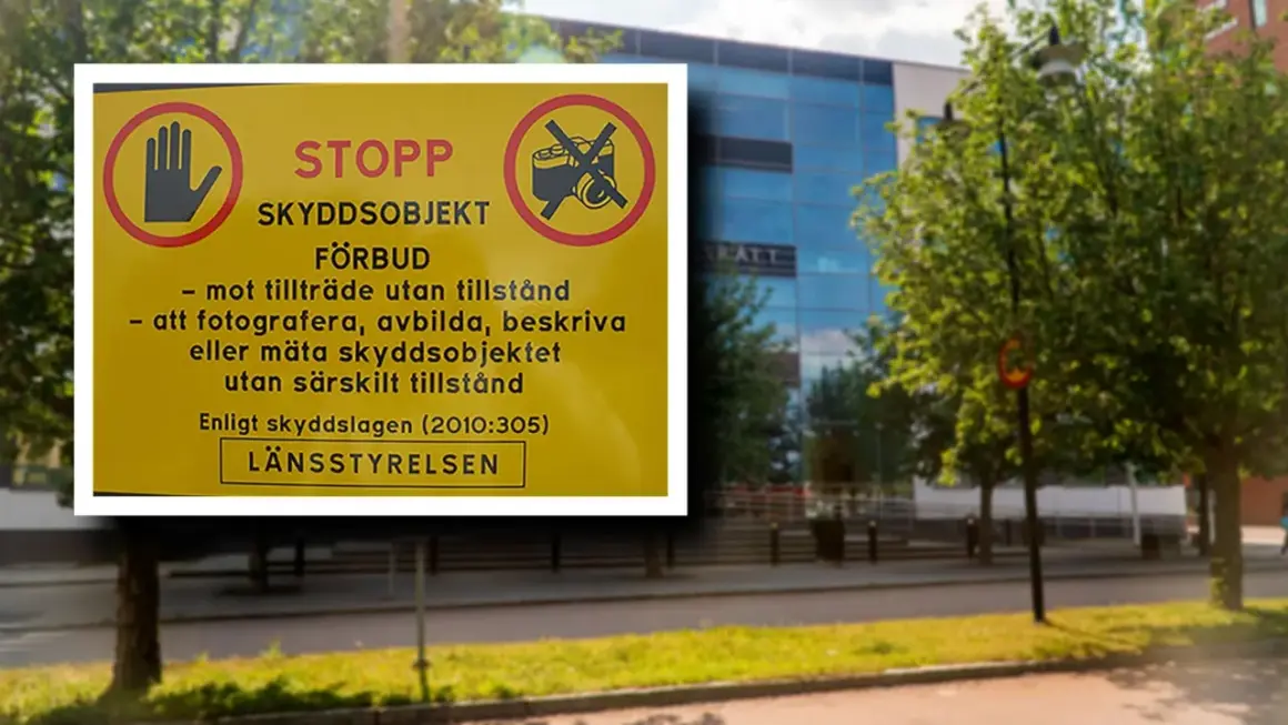 Gul skylt med texten "STOPP SKYDDSOBJEKT FÖRBUD" och symboler som visar att fotografering och inträde är förbjudet. Detta är en varning för olovlig avbildning av skyddsobjekt.