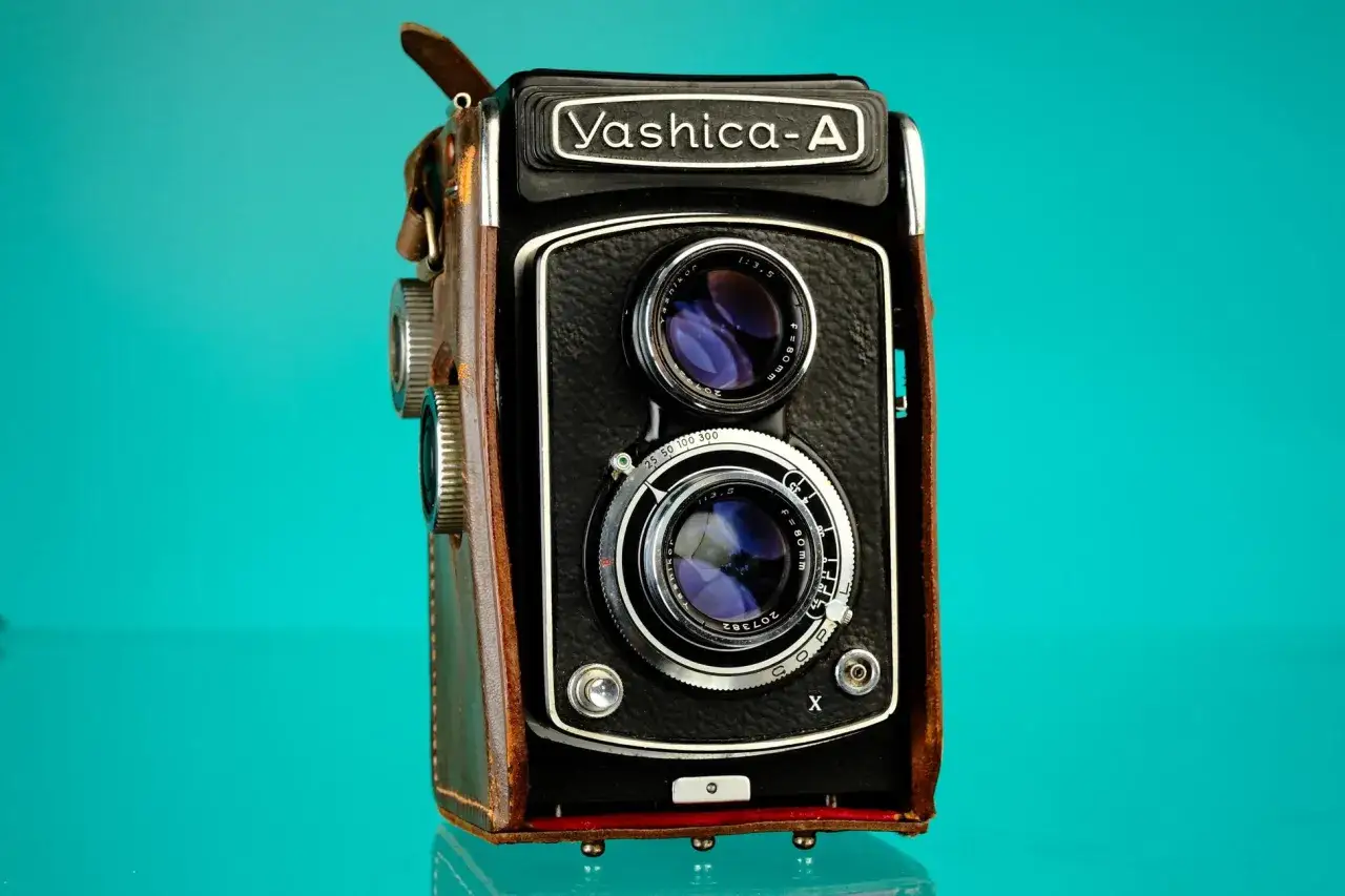 En vintage Yashica-A kamera i brunt l&auml;derfodral, redo att f&aring;nga minnen.