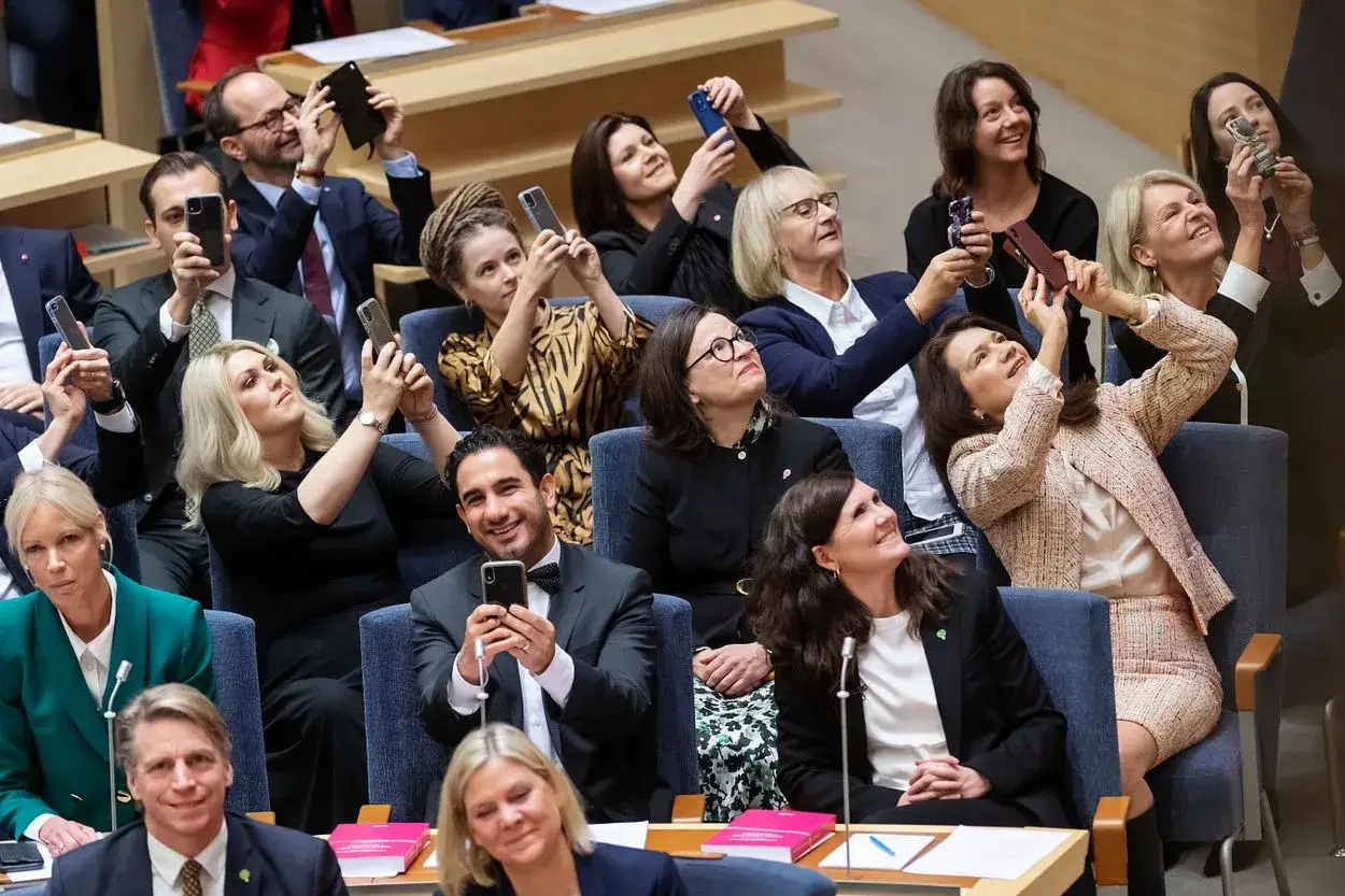 Publiken dokumenterar ögonblicket med mobilkameror, kanske för nomineringar till årets bild. Många ler och tittar uppåt.