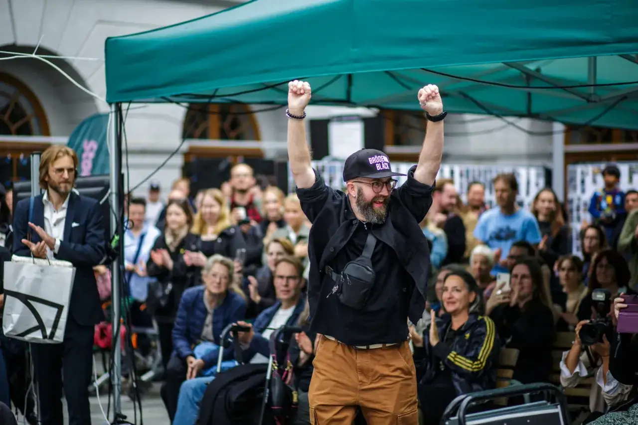 Glad deltagare med uppstr&auml;ckta armar under stockholm fotomaraton.
