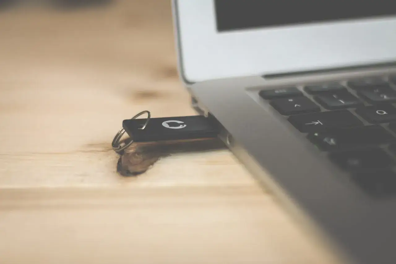 Ett USB-minne anslutet till en laptop, redo att spara bilder.