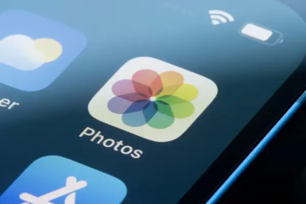 iPhone-skärm med "Photos"-ikonen, perfekt för att redigera bilder.