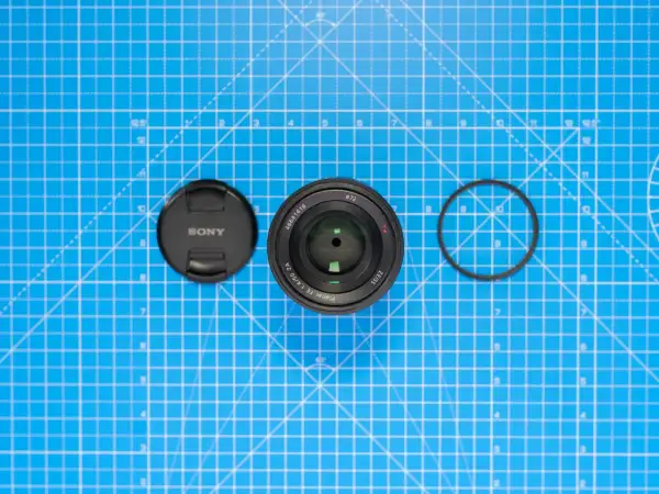 Sony-objektiv med lock och filterring på blått rutmönster. Lär dig vad distorsion betyder för bildkvaliteten.