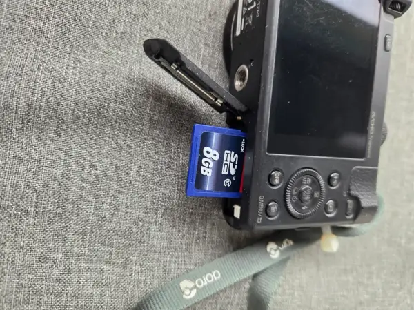 Ett SD-kort på 8GB sätts in i en Panasonic Lumix TZ60.